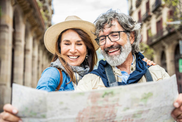A smiling retired couple looking at a map together while traveling