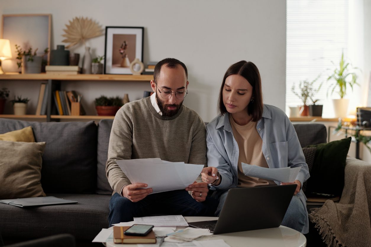 A young couple in their thirties reviewing a retirement plan with their financial advisor